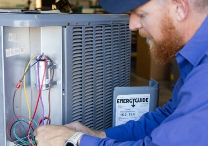 A Savage Air Conditioning technician working on a hvac unit.